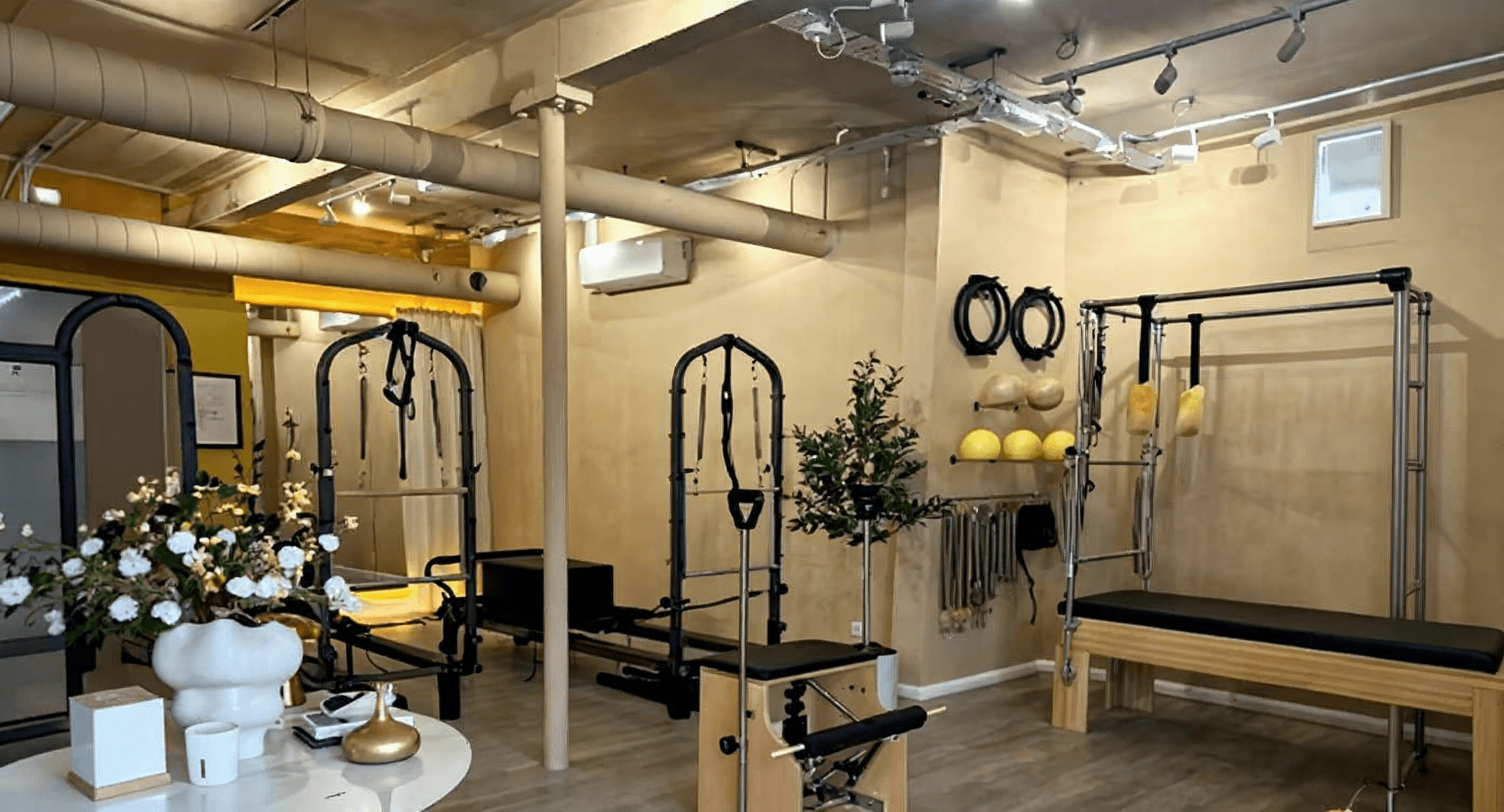 Studio Solena interior showing Pilates reformer equipment in a warm, elegant space with exposed ceiling and natural lighting